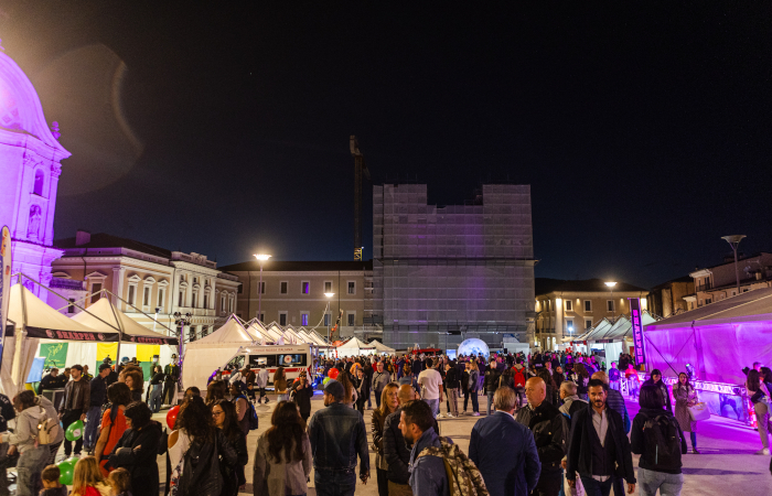 night view of a square in the center of L'Aquila, with stands and visitors