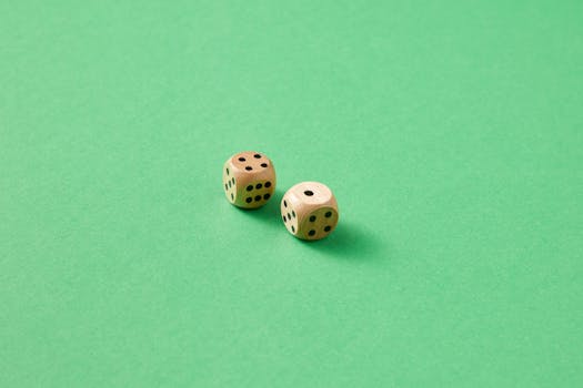 Close-up of two wooden dice on a vibrant green background.